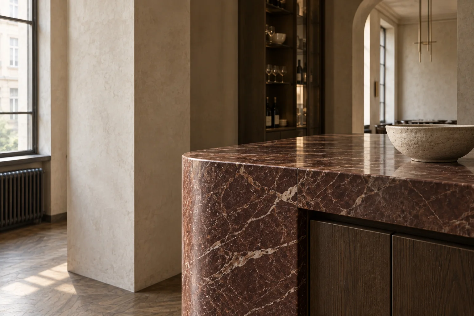 A close architectural view of the restaurant’s reddish stone counter, smoked oak joinery and clay plaster
